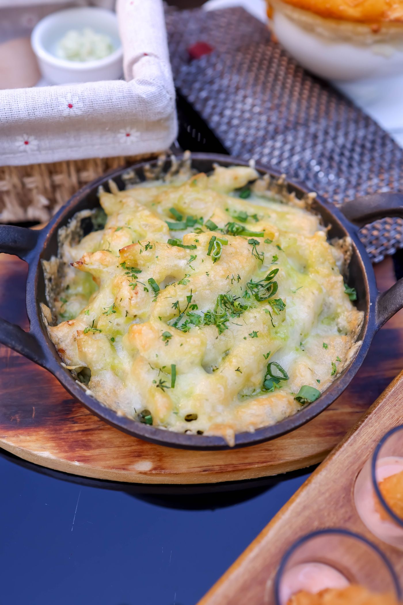 Baked macaroni & cheese with scallions; short pasta covered with melted pale cheese, scallion slices, lightly browned cheesy edges