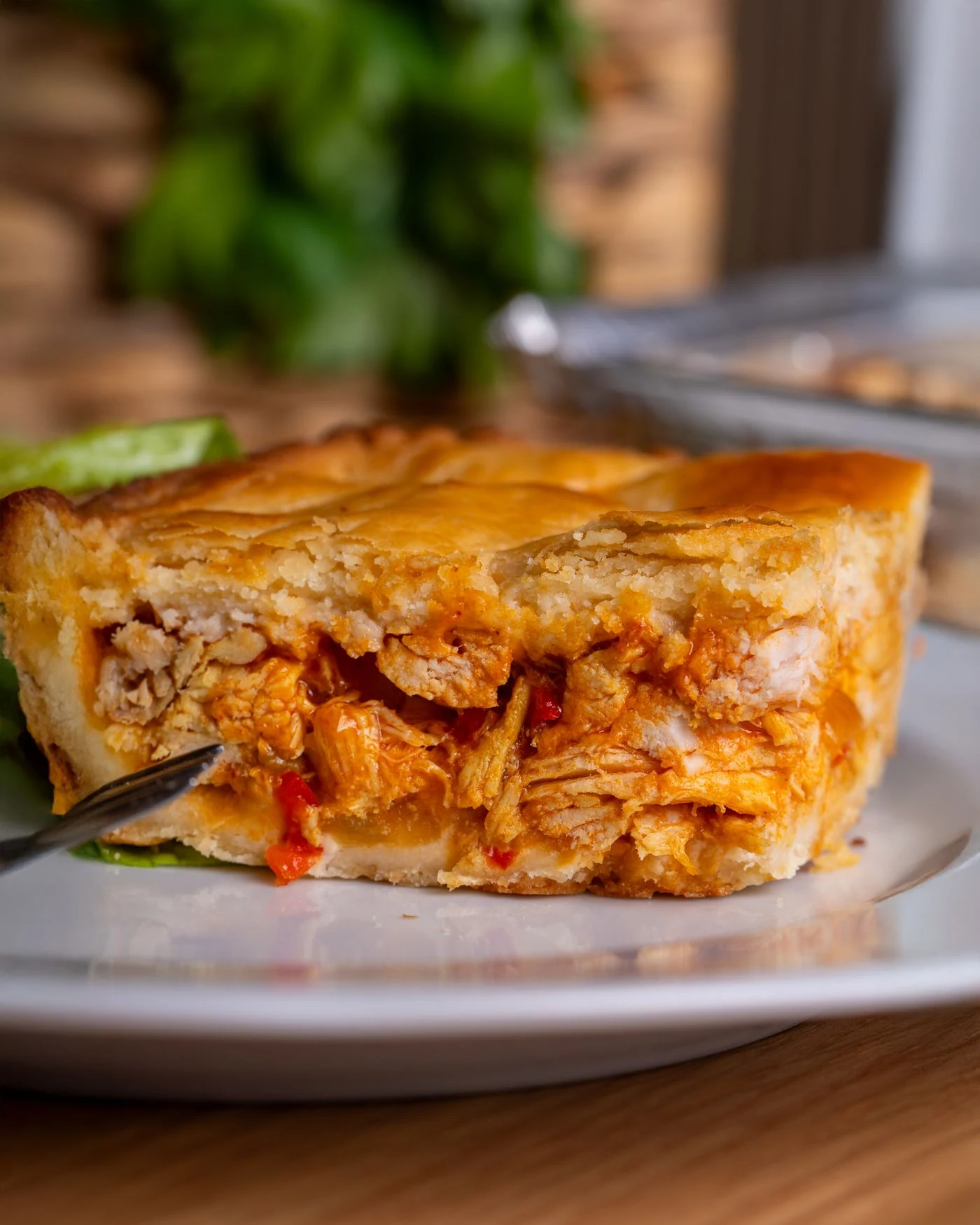 Golden double-crust chicken and red pepper pie cut open to show its filling