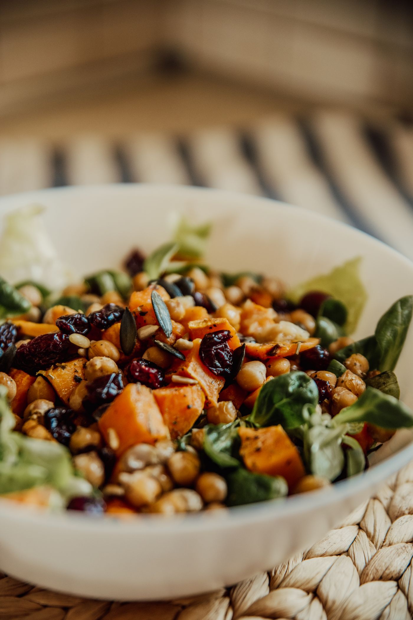 Sweet potato & chickpea harvest salad; chickpeas, roasted orange sweet potato cubes, leafy greens, dark dried cranberries