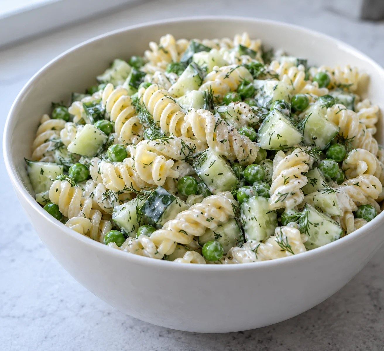 Tender short pasta and peas cool before meeting crisp cucumber and a lemon-dill yogurt dressing.