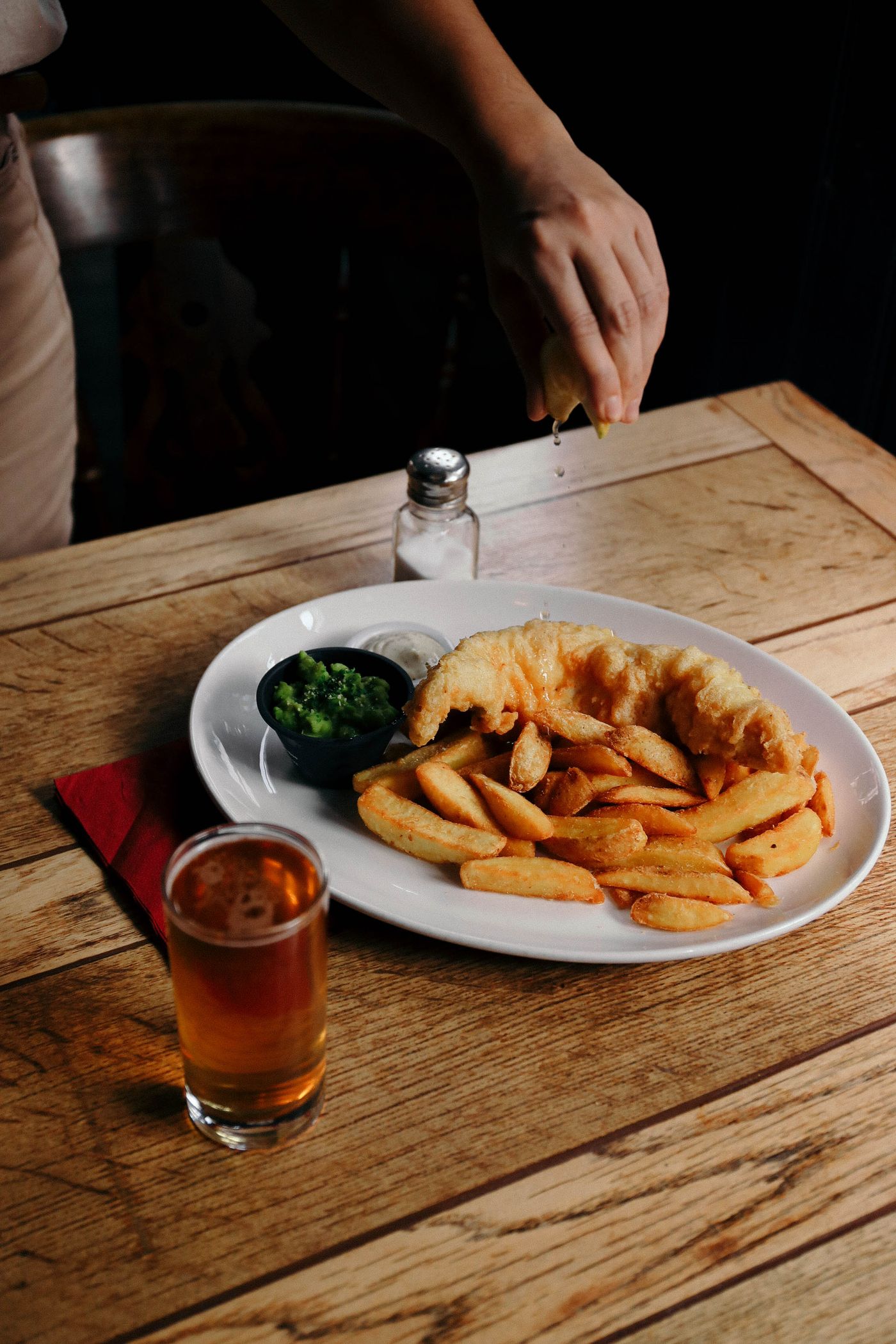 Crispy fish and chips with peas. battered white-fish fillet; thick-cut chips; green peas.