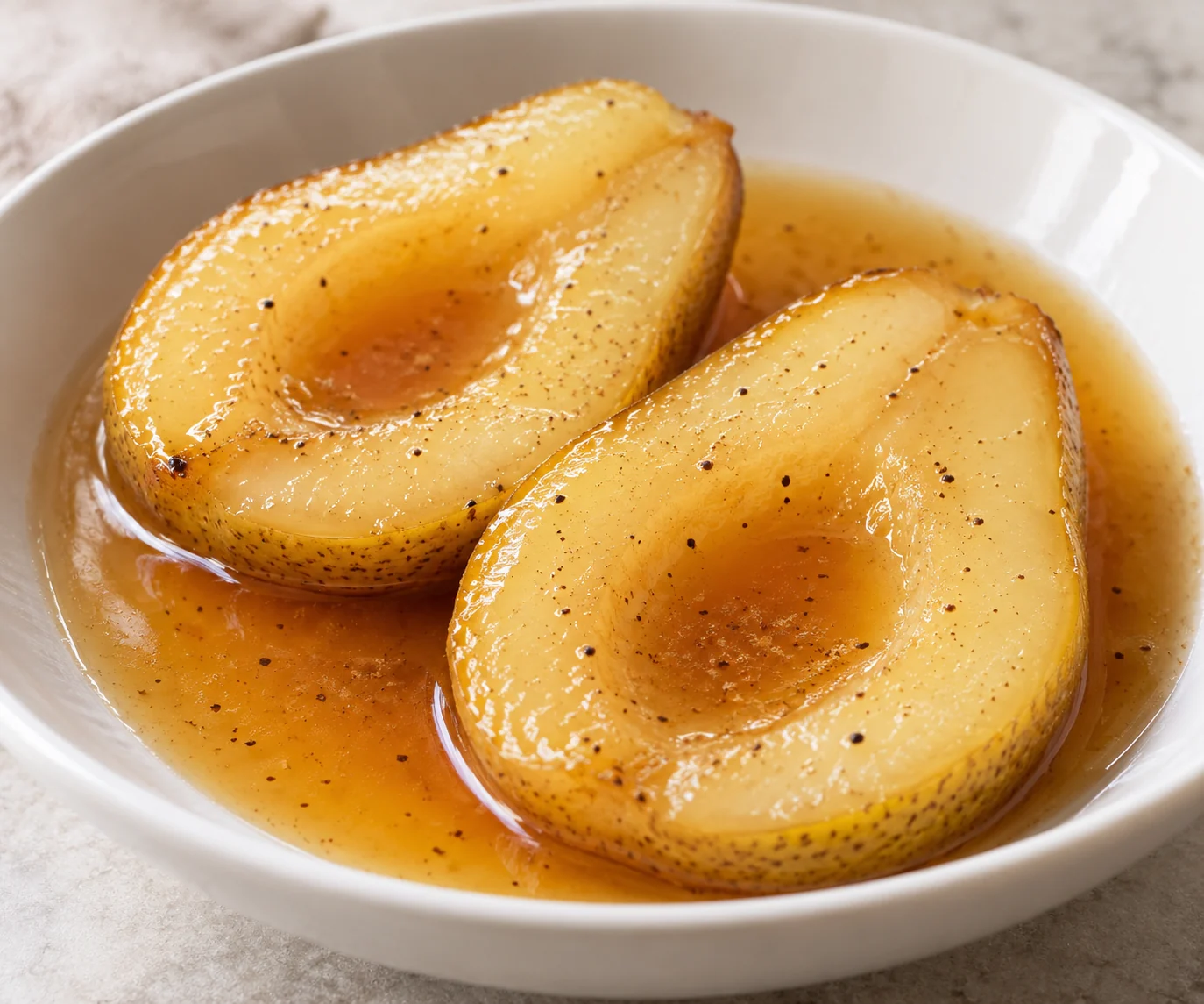 Skin-on pear halves gently poach in orange juice and cardamom, then receive all of the reduced syrup.