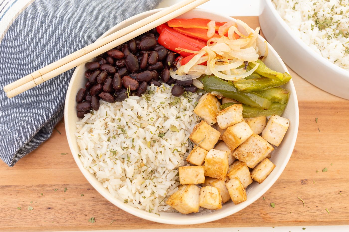Tofu & black bean rice bowl; golden tofu cubes, white rice, black beans, red and green bell pepper strips